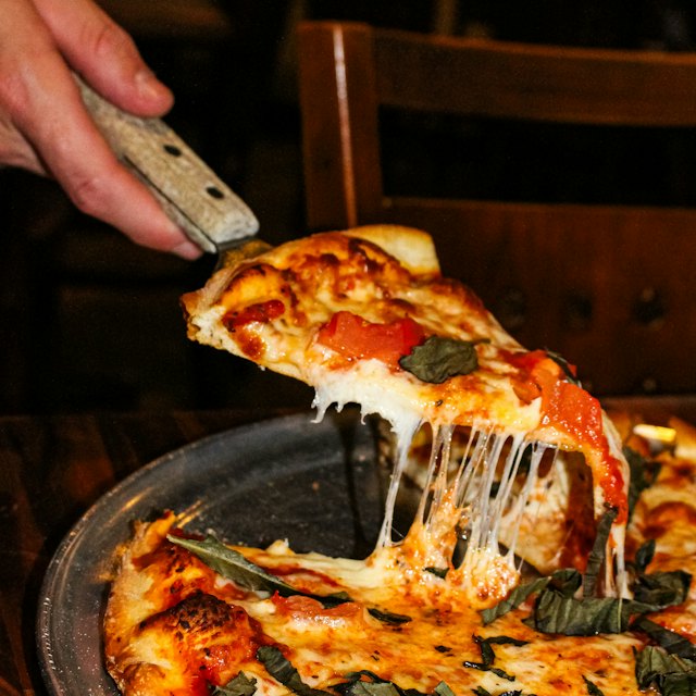 Fatia de pizza com queijo derretendo